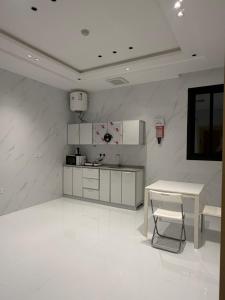 a kitchen with a table and a table and a counter at شقق واحة المحمدية in Baljurashi