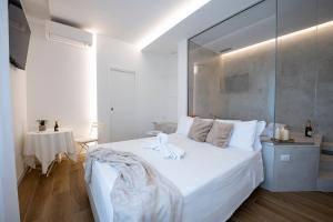 a bedroom with a large white bed and a table at La Nuvola in Chieti
