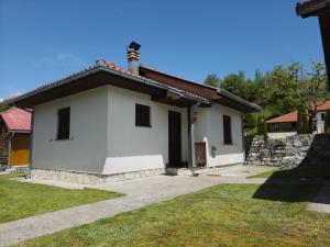 a small white house with a cross on the roof at Apartmani LUX in Kolašin