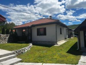 a small white house with a red roof at Apartmani LUX in Kolašin