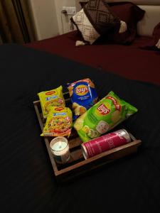 a tray with snacks and a candle on a bed at Sunbliss Corner in Greater Noida