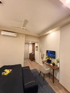 a living room with a couch and a desk with a computer at Sunbliss Corner in Greater Noida