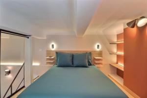 a bedroom with a bed with a blue pillow at Duplex Mirabeau - Hyper center city - Calm in Aix-en-Provence