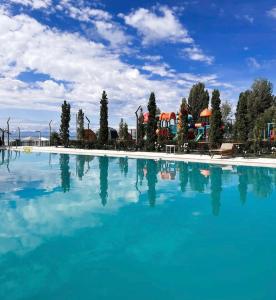 a large pool of blue water in a resort at Novel apartment in Korumdy