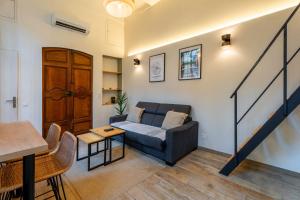 a living room with a couch and a staircase at Duplex Mirabeau - Hyper center city - Calm in Aix-en-Provence