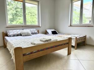 two beds in a room with two windows at Anit Rooms in Luštica