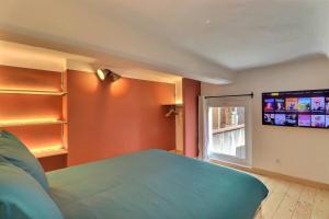 a bedroom with a bed and a flat screen tv at Duplex Mirabeau - Hyper center city - Calm in Aix-en-Provence +5 photos