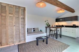 a living room with a table and a kitchen at La Cabane du Cap - Jacuzzi & City Center Nearby in Aix-en-Provence