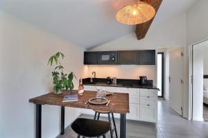 a kitchen with a wooden table in a room at La Cabane du Cap - Jacuzzi & City Center Nearby in Aix-en-Provence