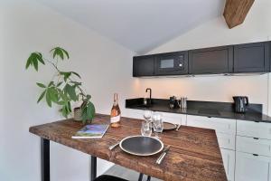 a kitchen with a wooden table with a bottle of wine at La Cabane du Cap - Jacuzzi & City Center Nearby in Aix-en-Provence +11 photos