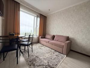 a living room with a couch and a table at Novel apartment in Korumdy