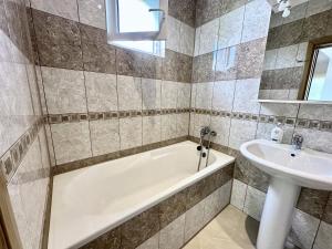 a bathroom with a tub and a sink at Anit Rooms in Luštica