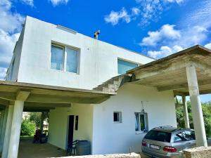 a man standing on top of a white house at Anit Rooms in Luštica
