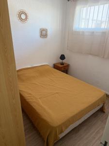 a bedroom with a bed and a window at L'Arletta in Saint-Cyprien-Plage