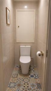 a bathroom with a toilet with a tile floor at L'Arletta in Saint-Cyprien-Plage