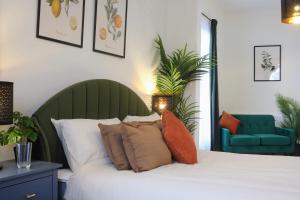 a bedroom with a white bed with a green headboard at SixCheapStreet in Newbury