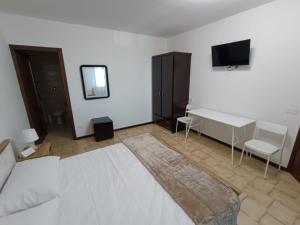 a bedroom with a bed and a desk and a tv at Casa di Brokka in Calvecchia +11 photos