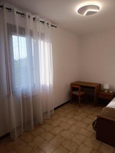 a bedroom with a bed and a window with curtains at Casa di Brokka in Calvecchia