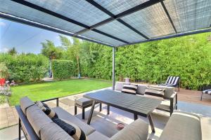 a patio with a table and chairs on a deck at La Cabane du Cap - Jacuzzi & City Center Nearby in Aix-en-Provence
