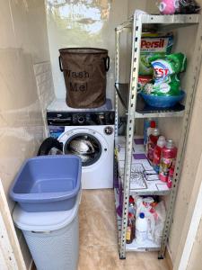 a laundry room with a washing machine and a shelf at Laniakea small apartment in the house in Risan in Risan