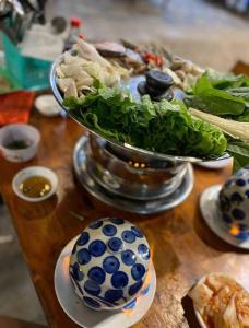 a table with a bowl of lettuce and a plate of food at Yen Phu Hotel Tuy Hòa in Tuy Hoa +74 photos