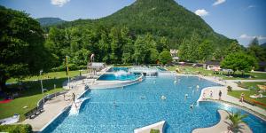 a large swimming pool with a mountain in the background at Jugendgästehaus Bad Ischl in Bad Ischl