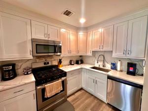 a kitchen with white cabinets and a stove top oven at The Chic Suite - 1BR with Luxe Amenities in Paterson