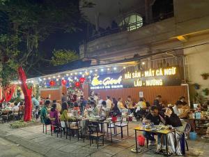 a group of people sitting at tables in front of a restaurant at Yen Phu Hotel Tuy Hòa in Tuy Hoa