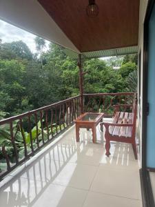 a porch with a bench and a table on a balcony at La Reina del Mar in Drake