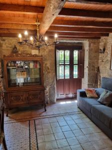 a living room with a couch and a tv at Casa Gasamáns in Amés
