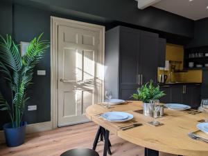 a dining room with a wooden table with plates on it at SixCheapStreet in Newbury