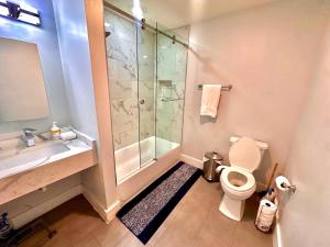 a bathroom with a shower and a toilet and a sink at The Chic Suite - 1BR with Luxe Amenities in Paterson +15 photos