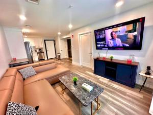 a living room with a couch and a large flat screen tv at The Chic Suite - 1BR with Luxe Amenities in Paterson