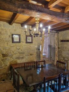 a dining room with a wooden table and chairs at Casa Gasamáns in Amés