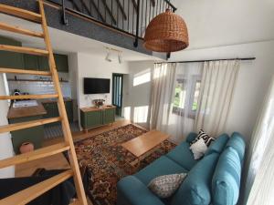 a living room with a blue couch and a bunk bed at Holiday Home Kostandinovic in Modriča
