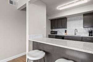 a large kitchen with a counter and two stools at Newly Renovated Unit in Central Spfld #301 in Springfield