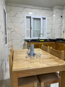 a kitchen with a wooden table with chairs and a sink at Soleil, mer & douceur à Staoueli in Alger +5 photos