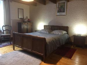 a bedroom with a large wooden bed with two pillows at Gîte de la Buissonniere in Grand-Failly +4 photos