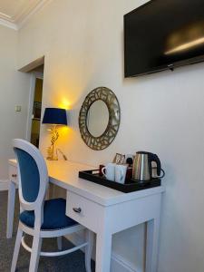 a desk with a chair and a mirror on a wall at Royal Sportsman Hotel in Porthmadog