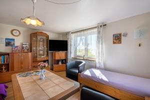 a living room with a table and a bedroom at FeWo Spreequelle in Herrnhut +35 photos