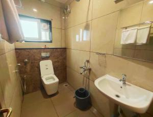 a small bathroom with a toilet and a sink at Hotel Royal Stay in Madurai