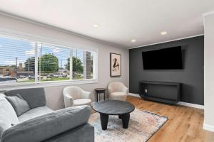 a living room with a couch and a tv at Newly Renovated Unit in Central Spfld #201 in Springfield
