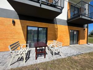 a patio with two chairs and a table next to a building at Diament Apartamenty in Rowy