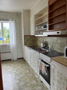 a kitchen with a sink and a stove at Strandvillan in Älandsbro