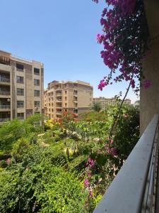 a view of a garden with flowers and buildings at Privado Modern Apartment Garden View B11 Group114 2BR in Madinaty