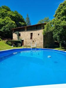 a large swimming pool in front of a stone building at Gasamans de arriba in Amés