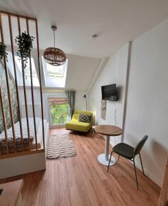 a living room with a yellow chair and a table at Das Jaartn - Boardinghouse Appartements & Ferienwohnung in Schönefeld