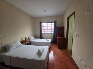 a bedroom with two beds and a window at Hotel Casona Macondo, Granada, Nicaragua in Granada