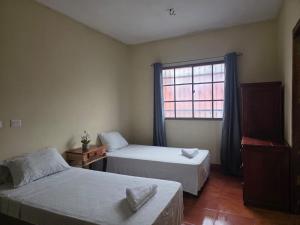 a bedroom with two beds and a window at Hotel Casona Macondo, Granada, Nicaragua in Granada