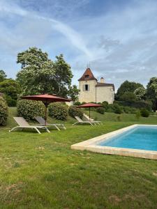 a group of chairs and umbrellas next to a swimming pool at Manoir BLANCHE HAUT Chambres et tables d hôtes in Villeneuve-sur-Lot